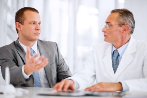 Mid adult businessman talking to a mature doctor.